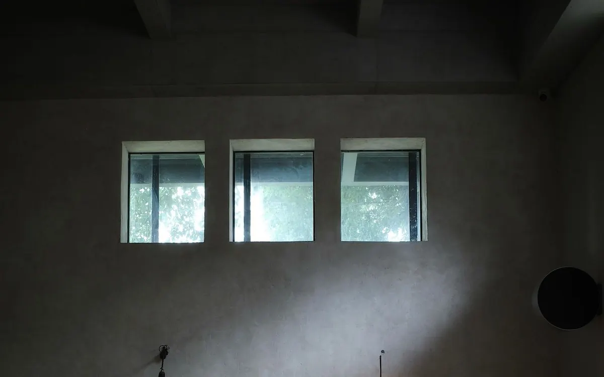 Dunkle, fein gespachtelte fugenlose Wand mit drei Oberlichtern