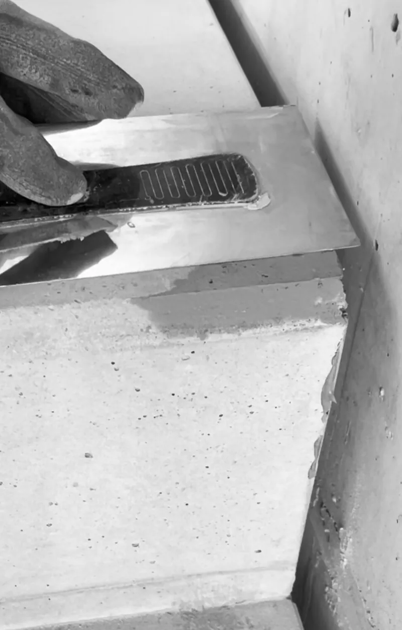 Eine Betonstufe wird mit der Glättkelle fein nachgearbeitet, Schwarz-Weiß-Aufnahme