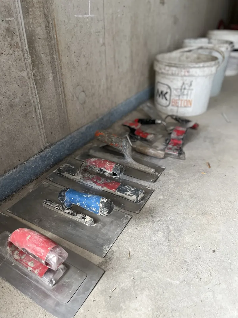 Kellen und Glättwerkzeuge für die Betonkosmetik, aufgereiht auf dem Boden