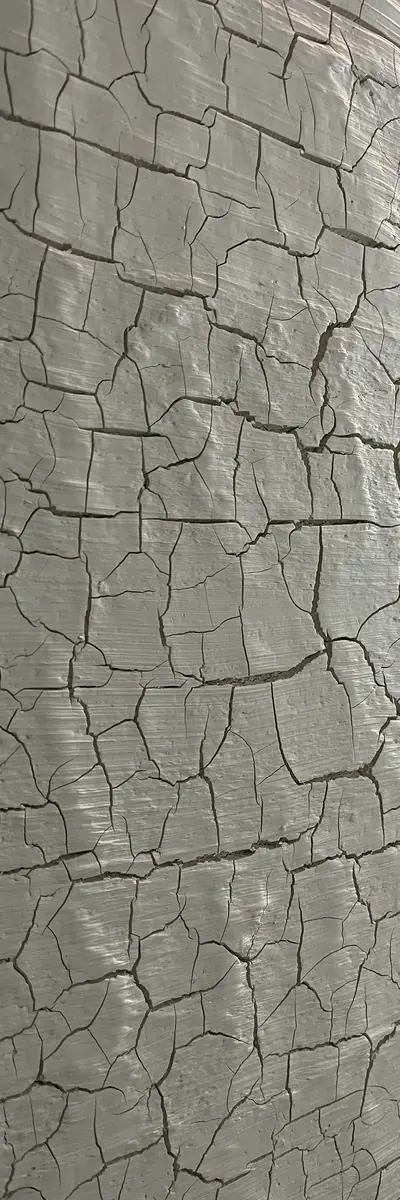 Helle Wand mit Kräckelstruktur, ein dichtes Netz aus feinen Rissen in der glatt gezogenen Spachtel