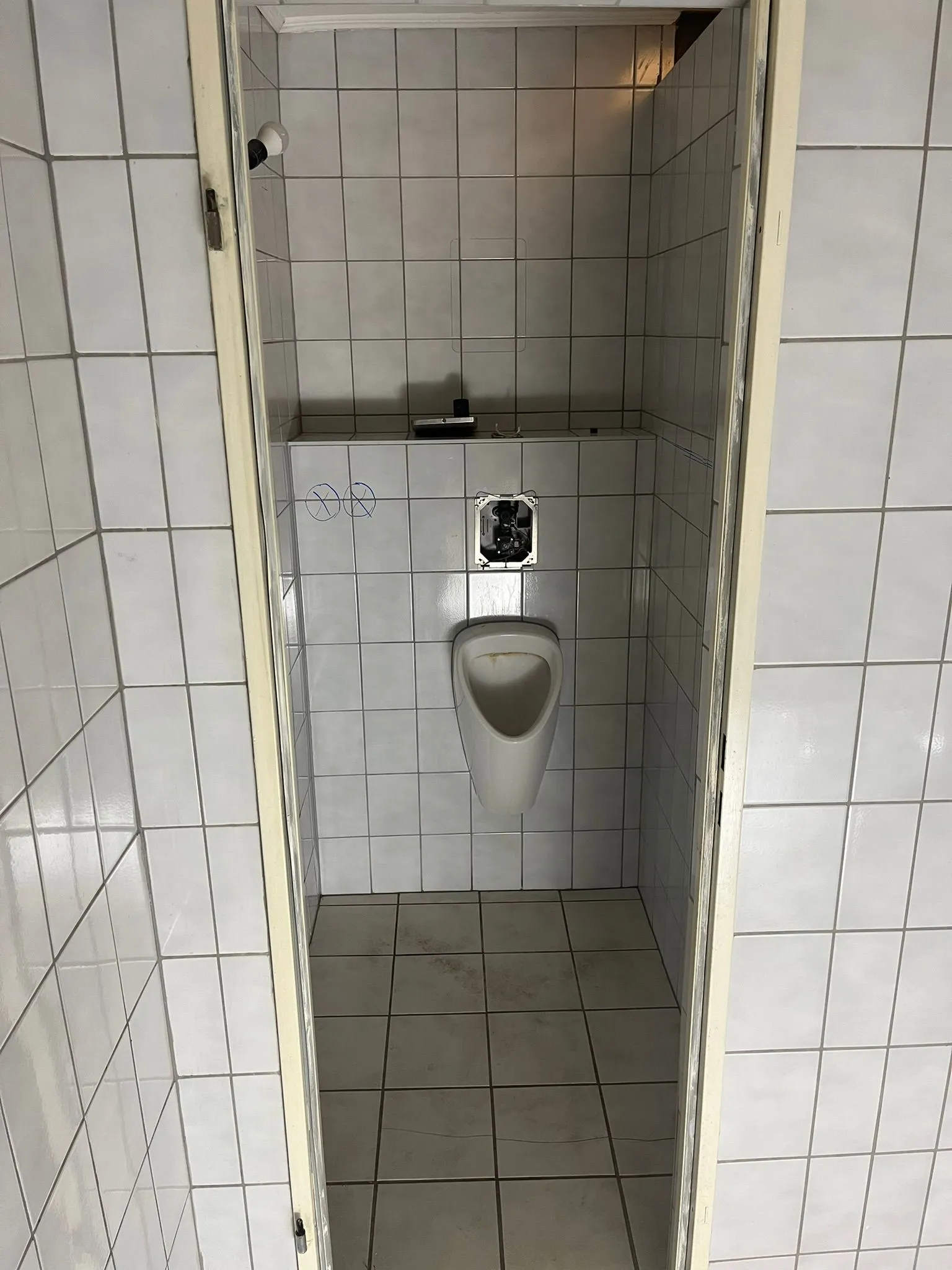 Vorher: geflieste Nische mit Urinal, Fugenraster an Wänden und Boden