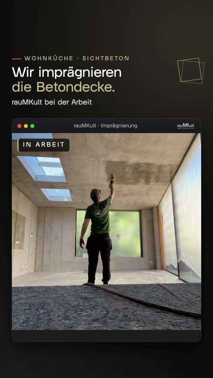 Handwerker im grünen rauMKult-Shirt sprüht Imprägnierung auf die Sichtbetondecke einer Wohnküche mit Dachfenstern und großem Fenster