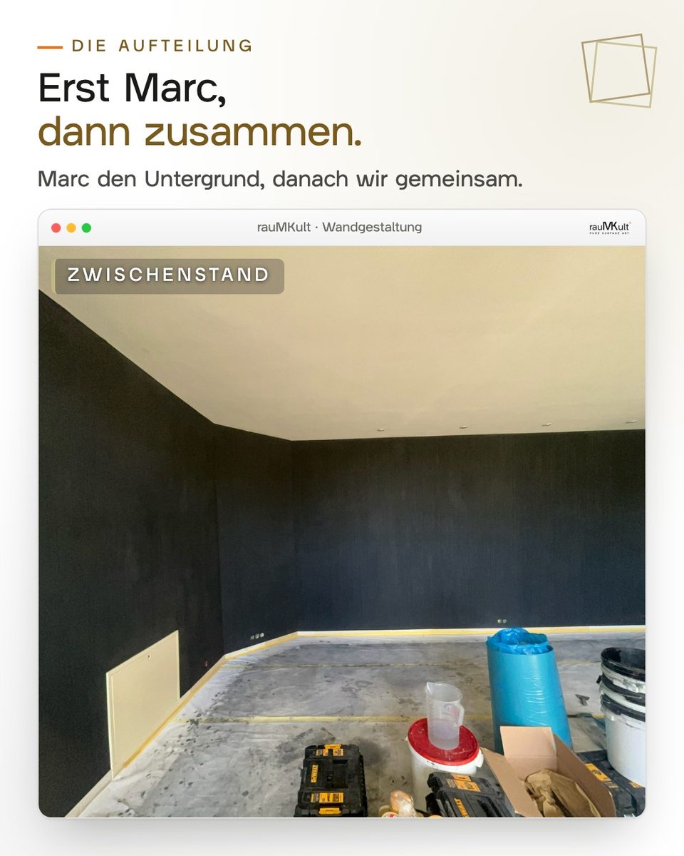 Zwischenstand: die schwarze Wand im noch leeren Raum, davor Eimer und Werkzeug