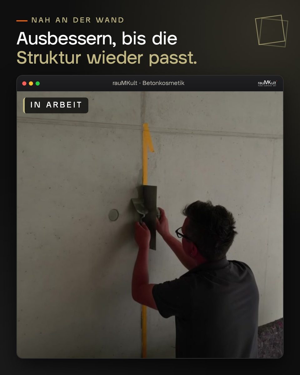 Handwerker bessert eine Sichtbetonwand mit dem Spachtel aus