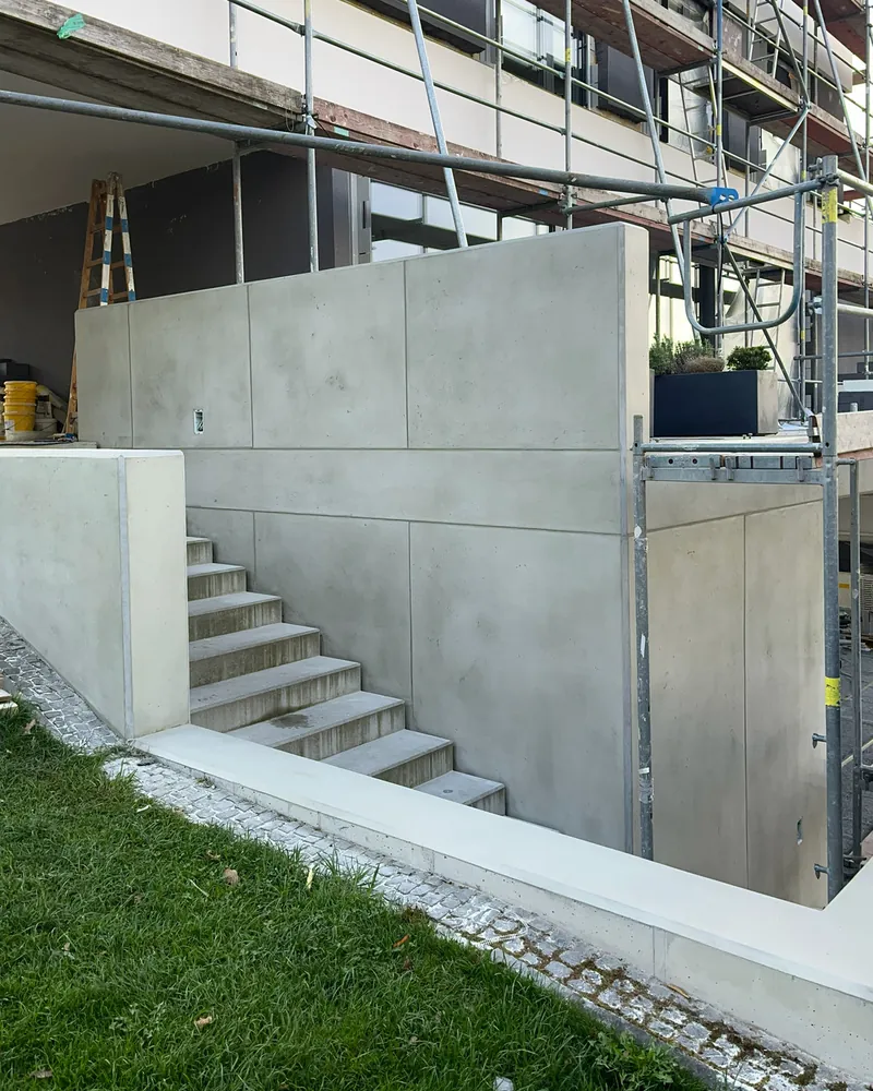 Fertige Betonmauer in Schalbetonoptik mit Fugenraster entlang der Gartentreppe