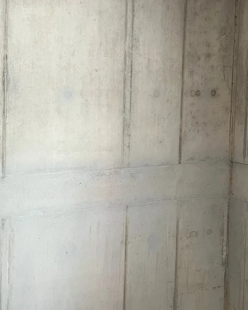 Sichtbetonwand im Treppenhaus des Wasserwerks Einsiedel nach der Betonkosmetik, Ankerkonen und Bohrlöcher geschlossen