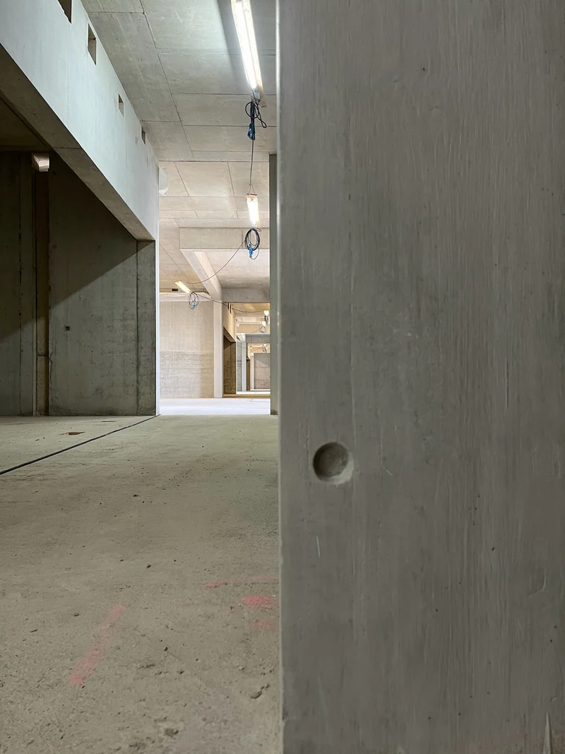 Fertig reparierter Pfeiler mit Holzstruktur und neu modelliertem Ankerkonus, Flur im Hintergrund