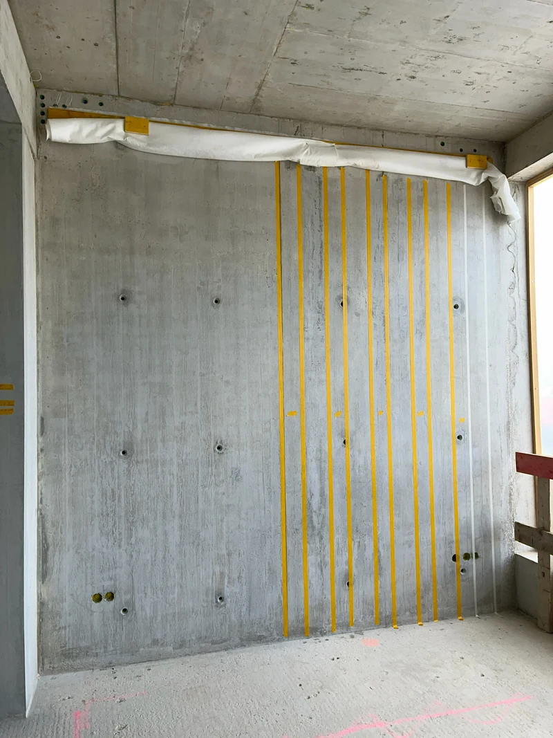 Erstes Rasterfeld an der großen Wand mit senkrechten gelben Klebebändern zwischen den Brettern abgeklebt