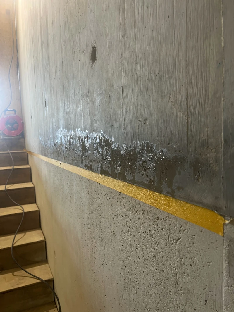 Schalungsfuge im Treppenaufgang mit gelbem Klebeband abgeklebt, darüber die vorbereitete Sichtbetonwand