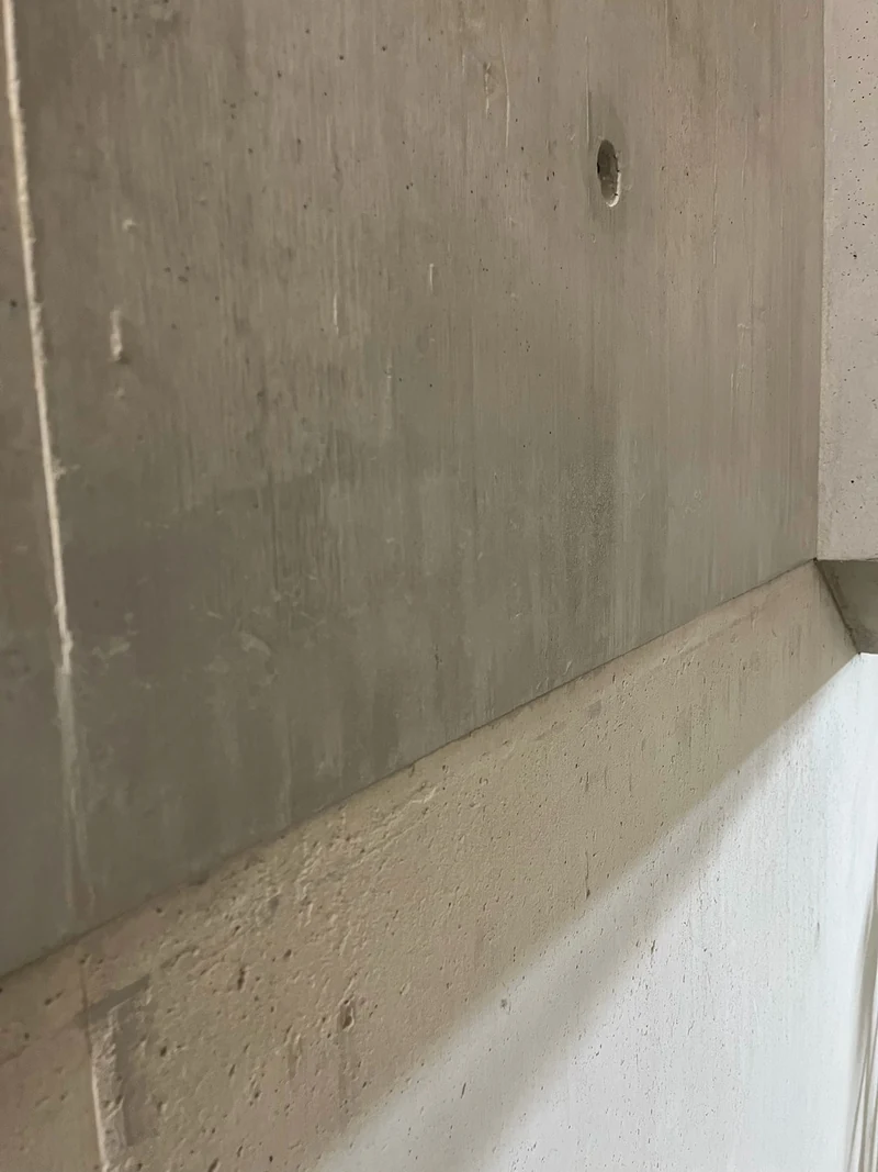 Geschlossene Schalungsfuge im Treppenaufgang, die Holzmaserung des Sichtbetons läuft über die Fuge hinweg