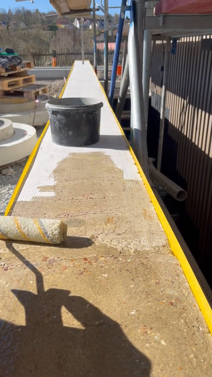 Video: Epoxidgrundierung wird auf der Mauerkrone zwischen zwei gelben Klebebändern aufgetragen