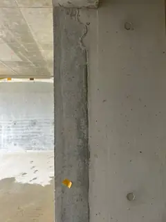 Betonstütze mit zwei Ankerkonen und gelben Klebemarkierungen, oben ein feiner Riss an der Kante