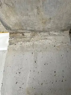 Anschluss von Wand und Decke mit rauer Arbeitsfuge, in der Wandfläche darunter viele kleine Lunker
