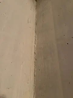 Innenecke aus zwei beigen Betonflächen mit feiner Kante in der Mitte und wenigen kleinen Lunkern