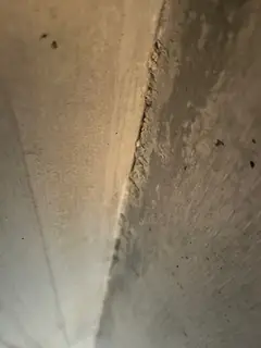 Spitz zulaufende Innenkante mit rauem, dunklem Streifen, links eine hell beschienene, glatte Fläche