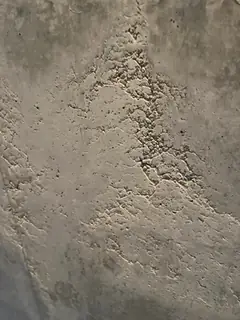 Schräg verlaufende Zone aus körnigen Ausbrüchen und Sandnestern auf einer sonst glatten Betonfläche