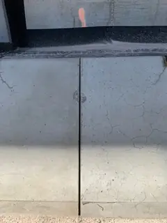 Zwei Betonplatten mit senkrechter Fuge unter einem Fenster, auf den Flächen feine Haarrisse