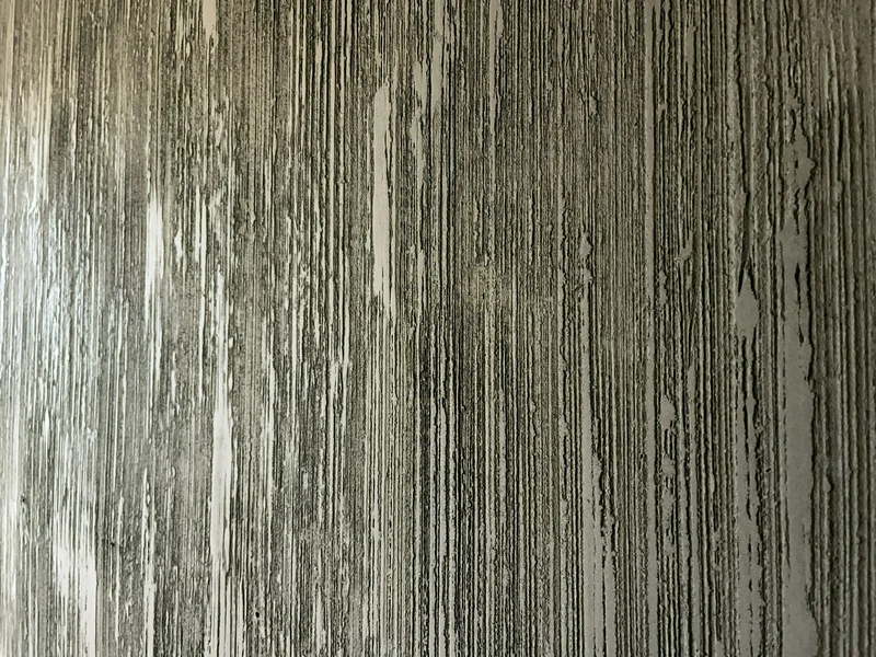 Frontale Nahaufnahme der Rasenoptik: helle Grate, dunkle Rillen, im Fensterlicht goldgrau wirkend