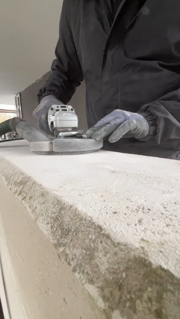 Video: Abgeblätterte Farbe wird mit dem Winkelschleifer von einer Mauerkrone geschliffen