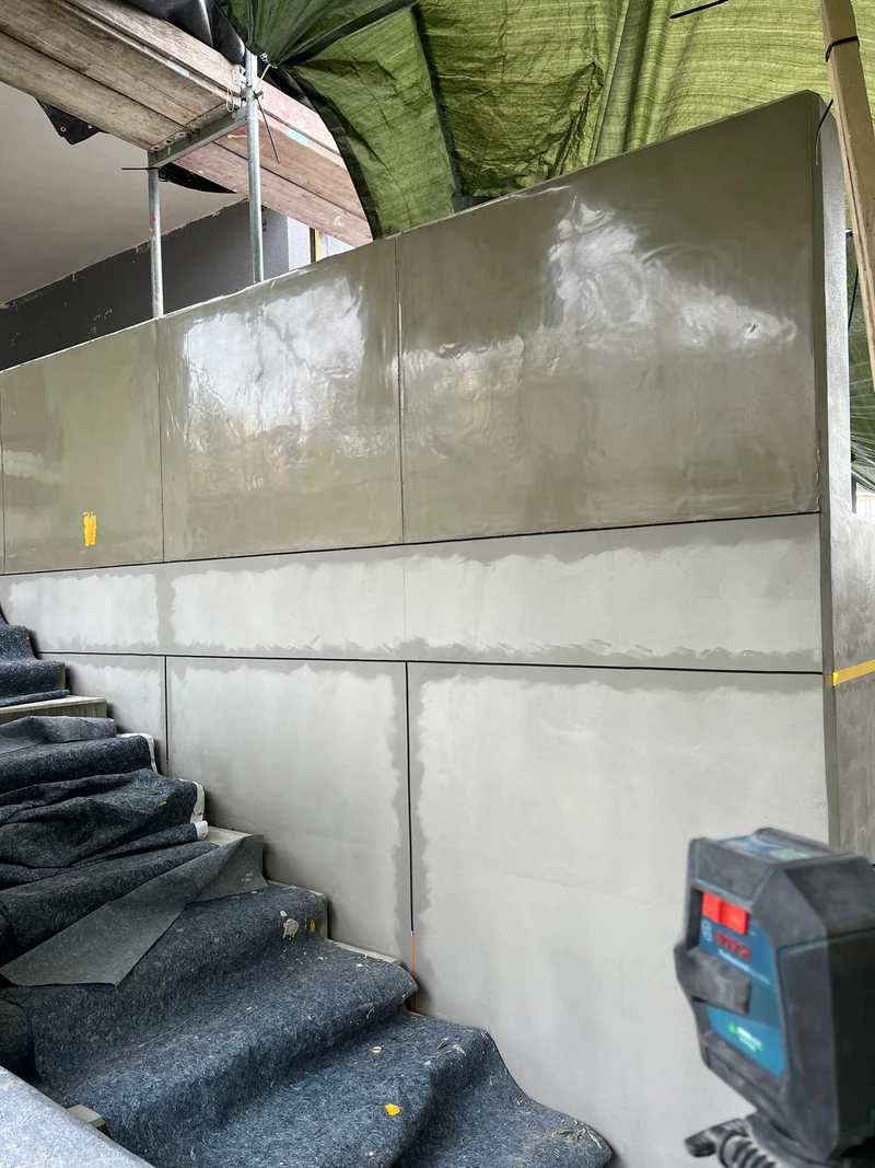 Treppenwand, von unten fotografiert, Erste Felder betoniert: Erste drei Felder der Schalbetonoptik mit Folie eingeschalt, darunter Moosgummiband, Hohenstein-Ernstthal