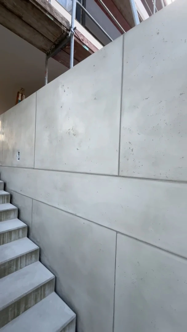 Video: Fertige Betonmauer in Schalbetonoptik mit Fugenraster, Poren und Lunkern an einer Treppe