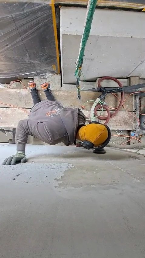Video: Handwerker schleift über Kopf die Unterseite eines Betondeckenstreifens