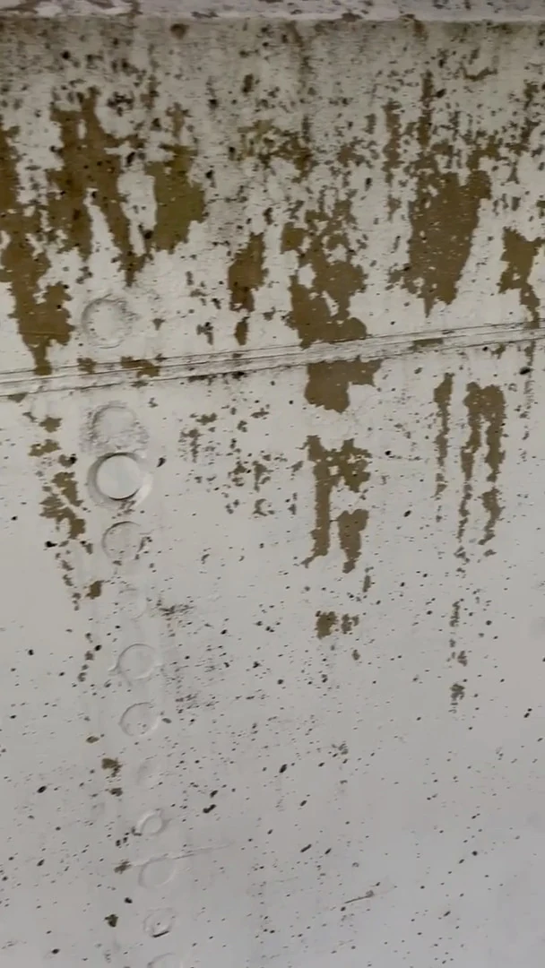 Video: Nahaufnahme abgeblätterter Farbe und Laufspuren auf einer Betonmauer im Außenbereich