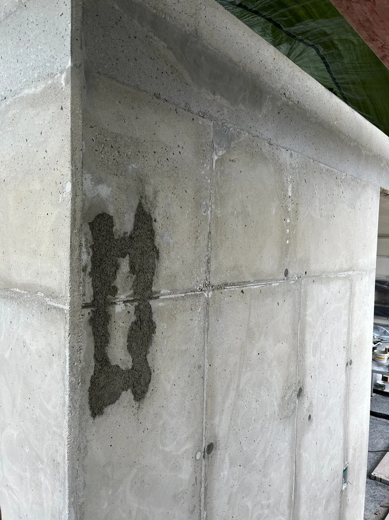 Mit Sanierungsmörtel aufgebaute Ausplatzung an der Ecke einer abgeschliffenen Betonmauer, Hohenstein-Ernstthal