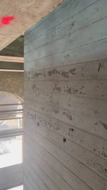 Wand im Aufzugsbereich: Ausgangslage, Streiflicht. Ausgangslage: Holzstruktur-Beton mit Ausbrüchen und Lunkern.