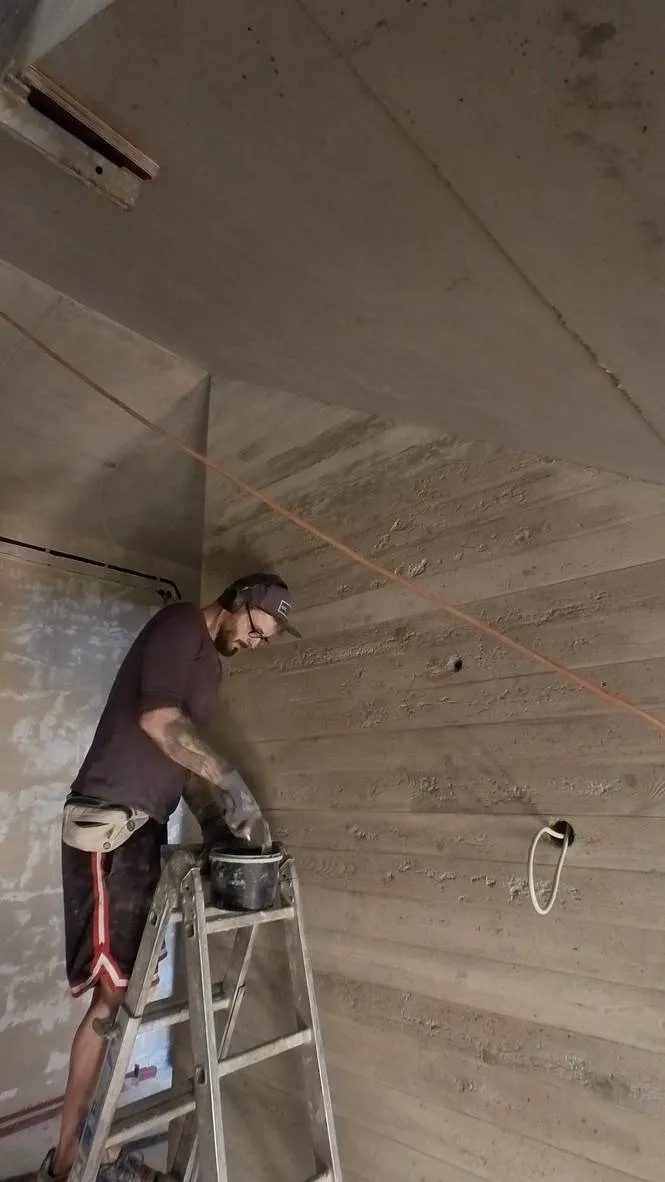Bearbeitung der Treppenhauswand von der Leiter aus.