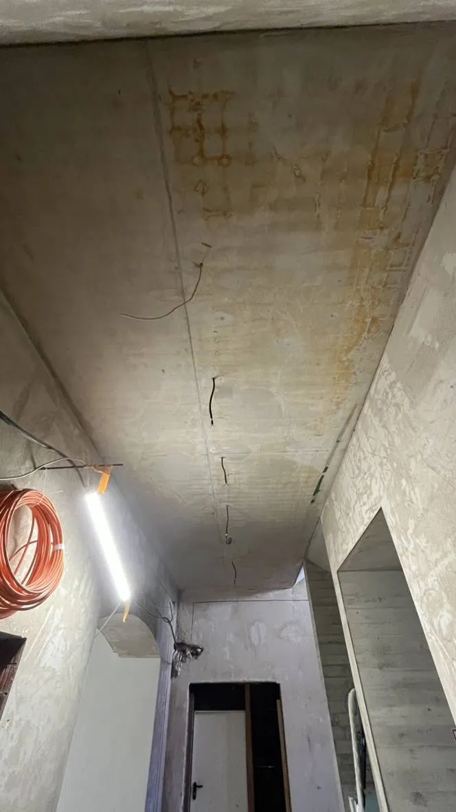 Betondecke mit Verfärbungen und Rissen vor der Reinigung.
