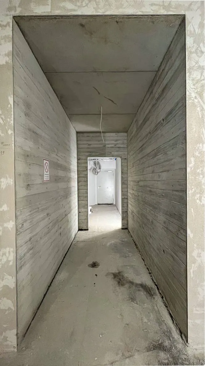 Betonflur mit symmetrischem Blick und Holzbrettstruktur.