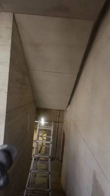 Gereinigte Treppenhausdecke und Wand im Durchgang.