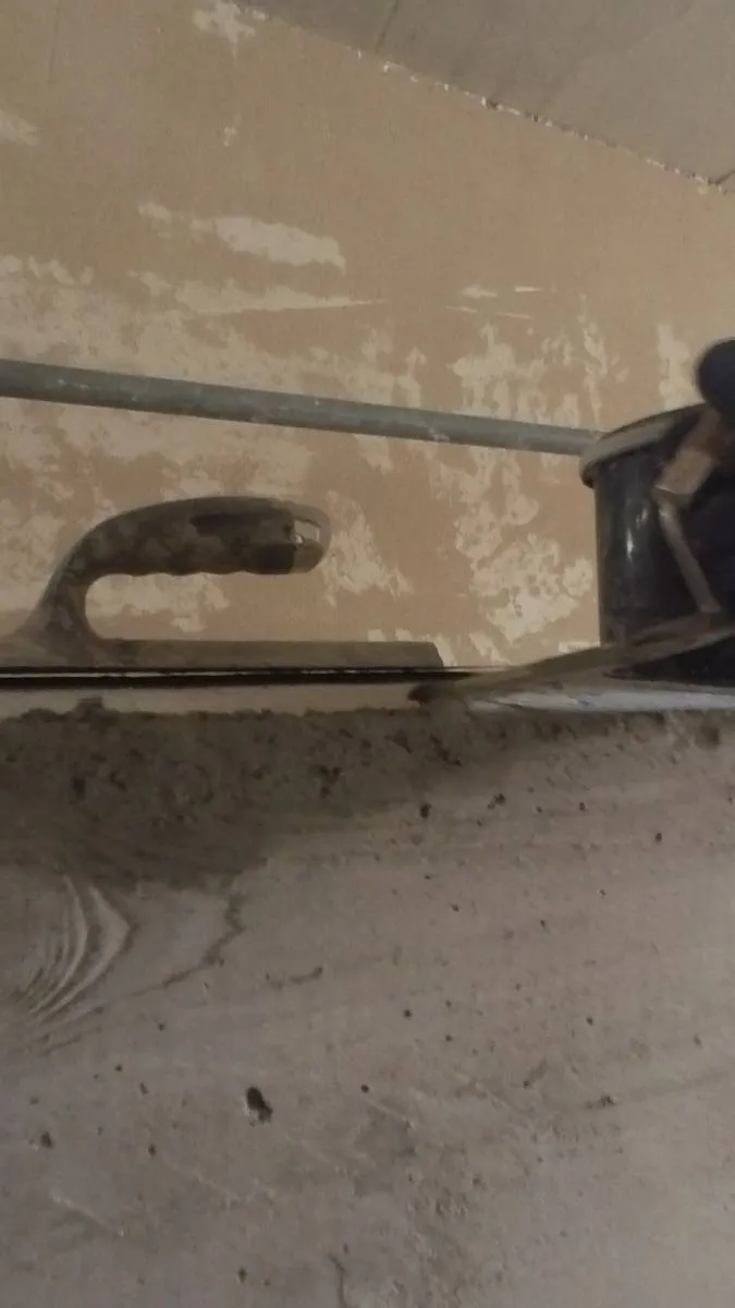 Wandkopf im Treppenhaus: Füllen mit dem Spachtel. Grobspachtel wird mit Kelle am Wandkopf aufgetragen.
