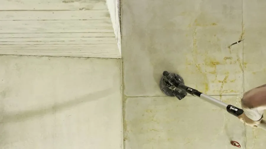 Reinigung der Betondecke mit Stielschleifer.