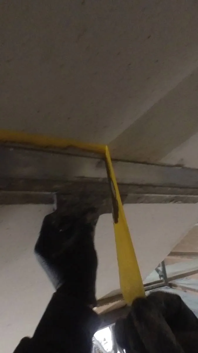 Der Spachtel wird entlang des Übergangs geführt, am Ende ist eine saubere Fuge erkennbar.