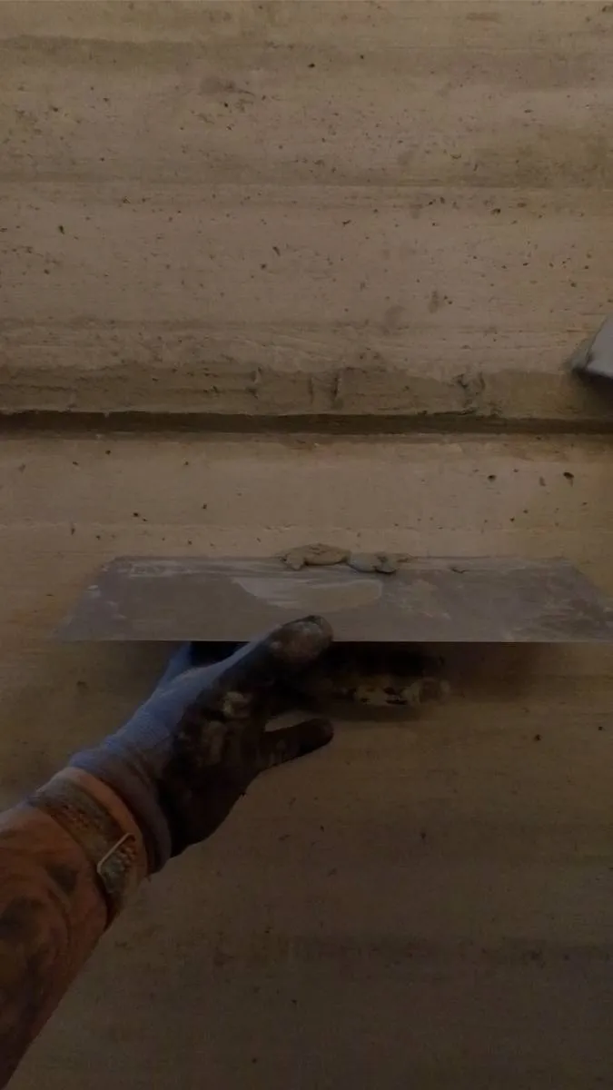 Spachtelmasse wird mit der Traufel auf die Wand aufgezogen.