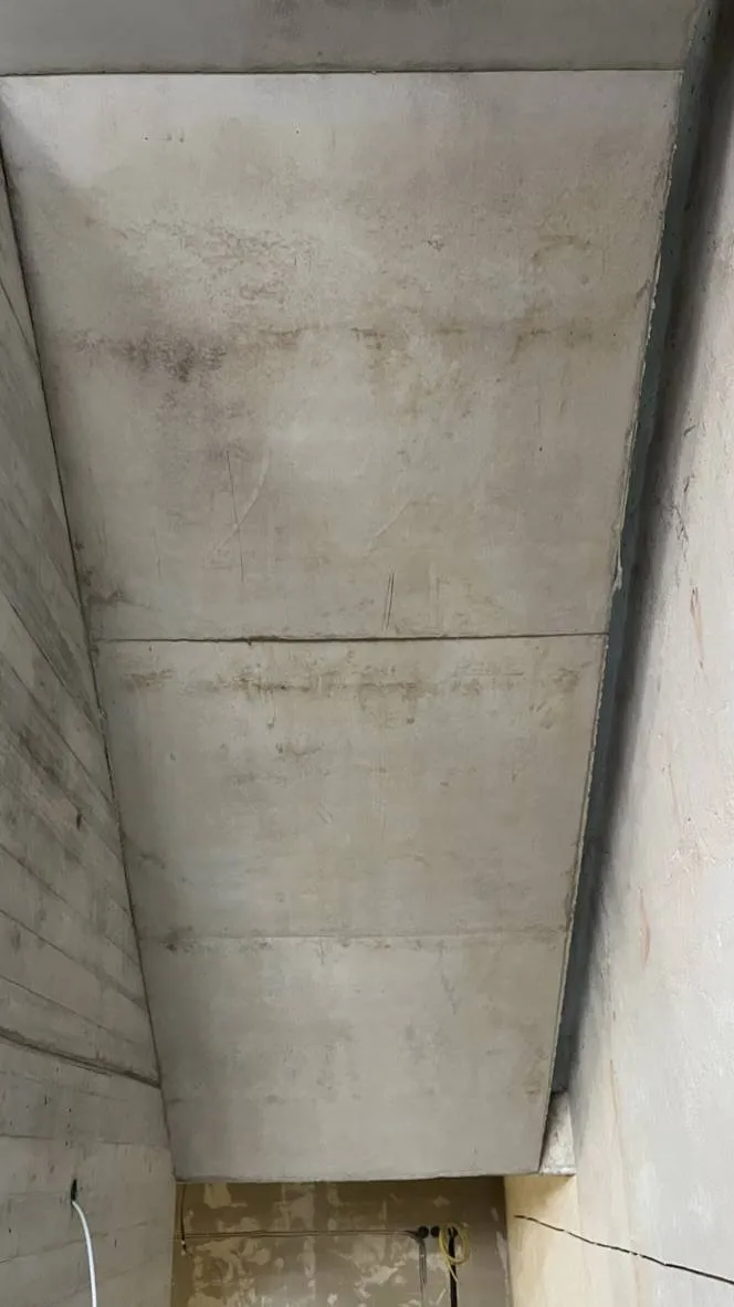 Treppenlaufunterseite vor der Reinigung mit Flecken und Rostfahnen.