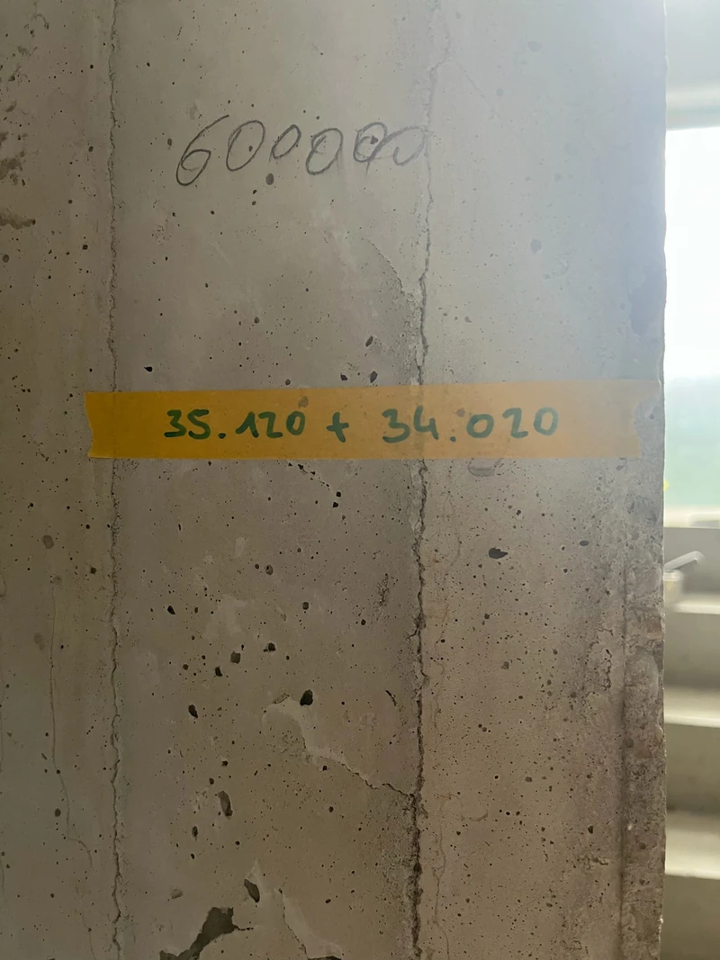 Klebeband mit handschriftlicher Farbtonrezeptur für den X-Fine Extrafeinspachtel an einer Betonwand im Erdgeschoss