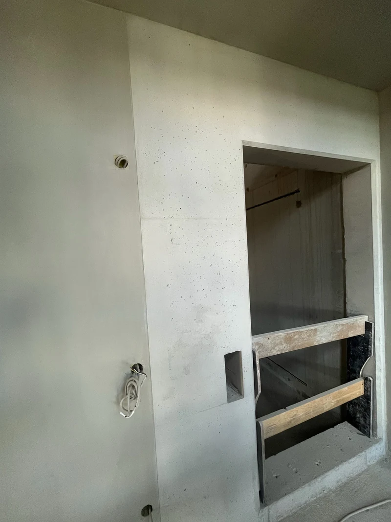 Nachher: Ortbeton mit erhaltenen Poren und Lunkern neben der Aufzugsöffnung, links das homogene Betonfertigteil