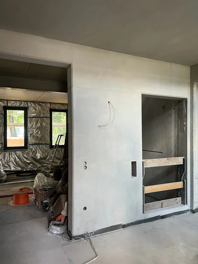 Nachher: Ortbetonwand am Aufzug im Erdgeschoss, Recyclingbeton mit sichtbarer Struktur und erhaltenem Schalbild