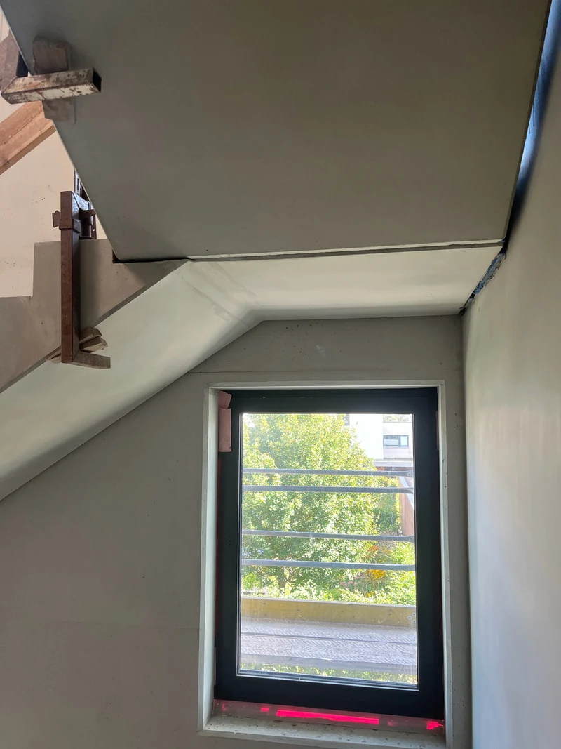 Nachher: schräge Podestunterseite aus Betonfertigteil über dem Fenster mit sauberen Kanten nach der Retusche