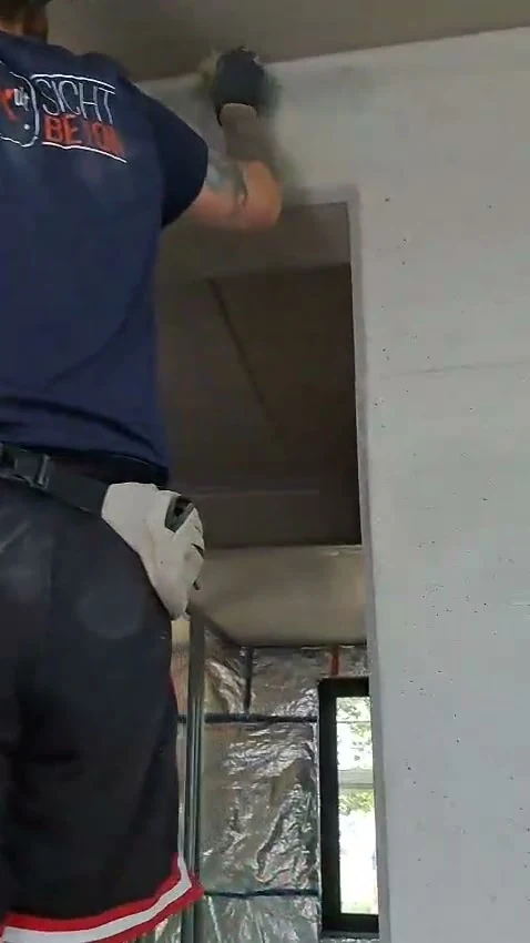 Video: Retusche am Ortbeton mit dem Naturschwamm von der Leiter aus, von hinten gefilmt, Fensteröffnung im Bild