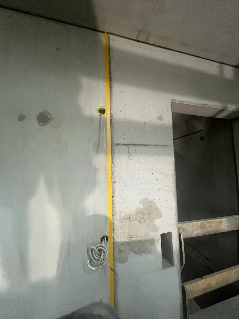 Vorbereitet: Absatz zwischen Betonfertigteil und Ortbeton am Aufzugskern, Kante abgeklebt, Kiesnest grundiert