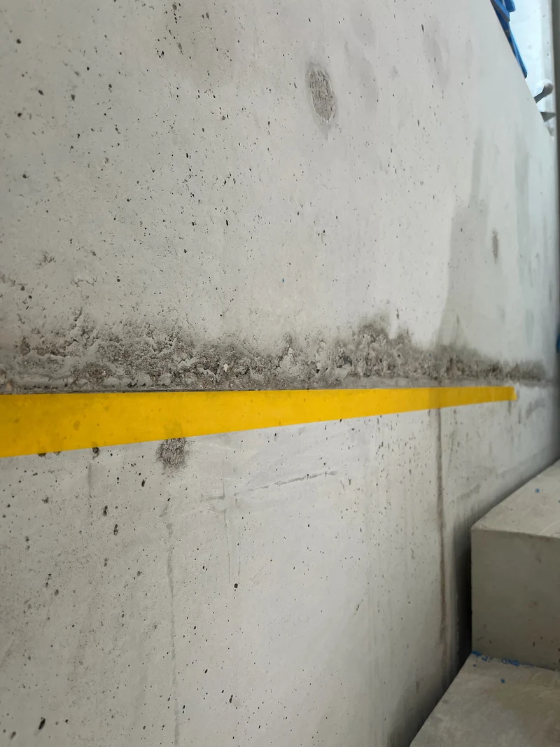 Vorbereitet: dieselbe Schalungsfuge am Ortbeton mit Klebeband abgeklebt, Poren und Lunker in der Fläche