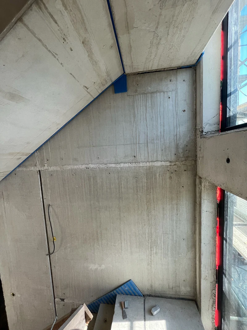 Vorher: Betonfertigteilwand am ersten Podest mit ausbetonierter Lagerfuge, Bohrlöchern der Abschalung und Schmutzspuren