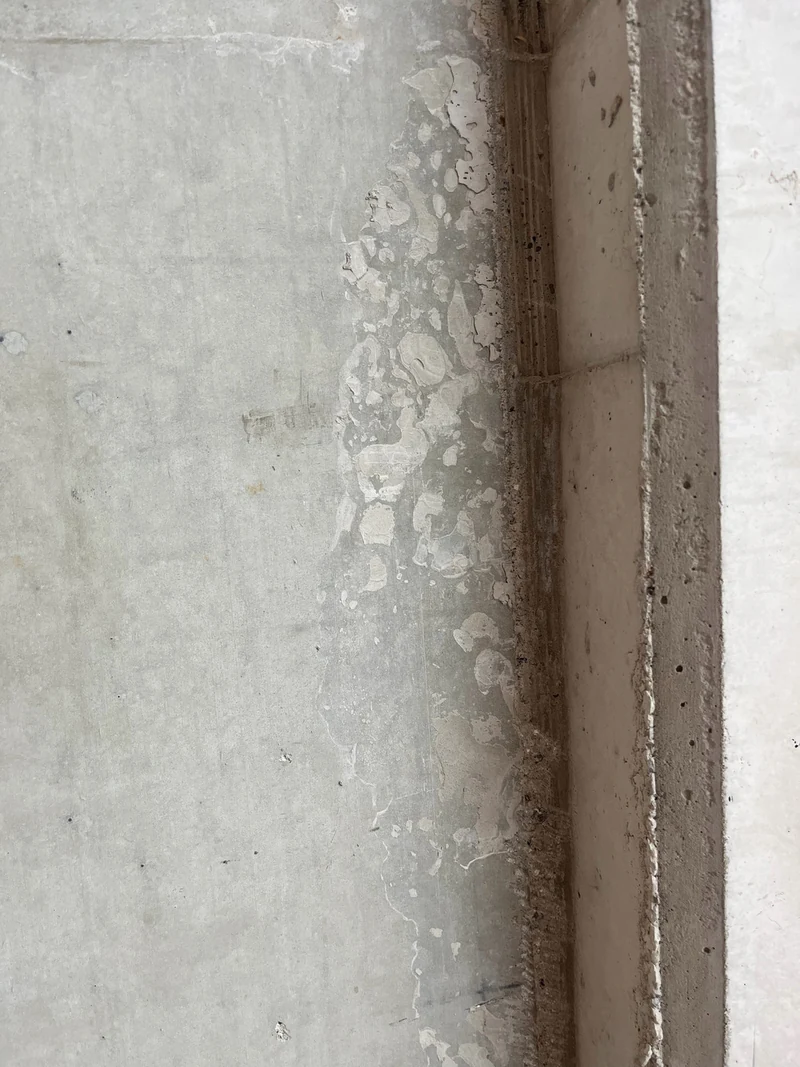 Vorher: Innenecke mit ausgelaufenem Beton und überstehender Dreikantfase, die gebrochen werden muss