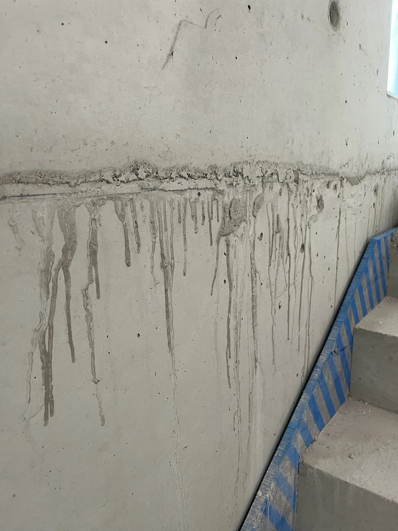 Vorher: Schalungsfuge der Ortbetonwand mit Holzdreikantleiste und ausgelaufenem Beton an der Fensterseite