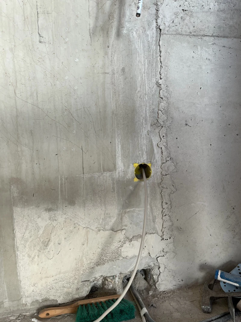Vorher: senkrechter Übergang zwischen Ortbeton und Betonfertigteil mit Elektrodose und Kabel am Aufzugskern