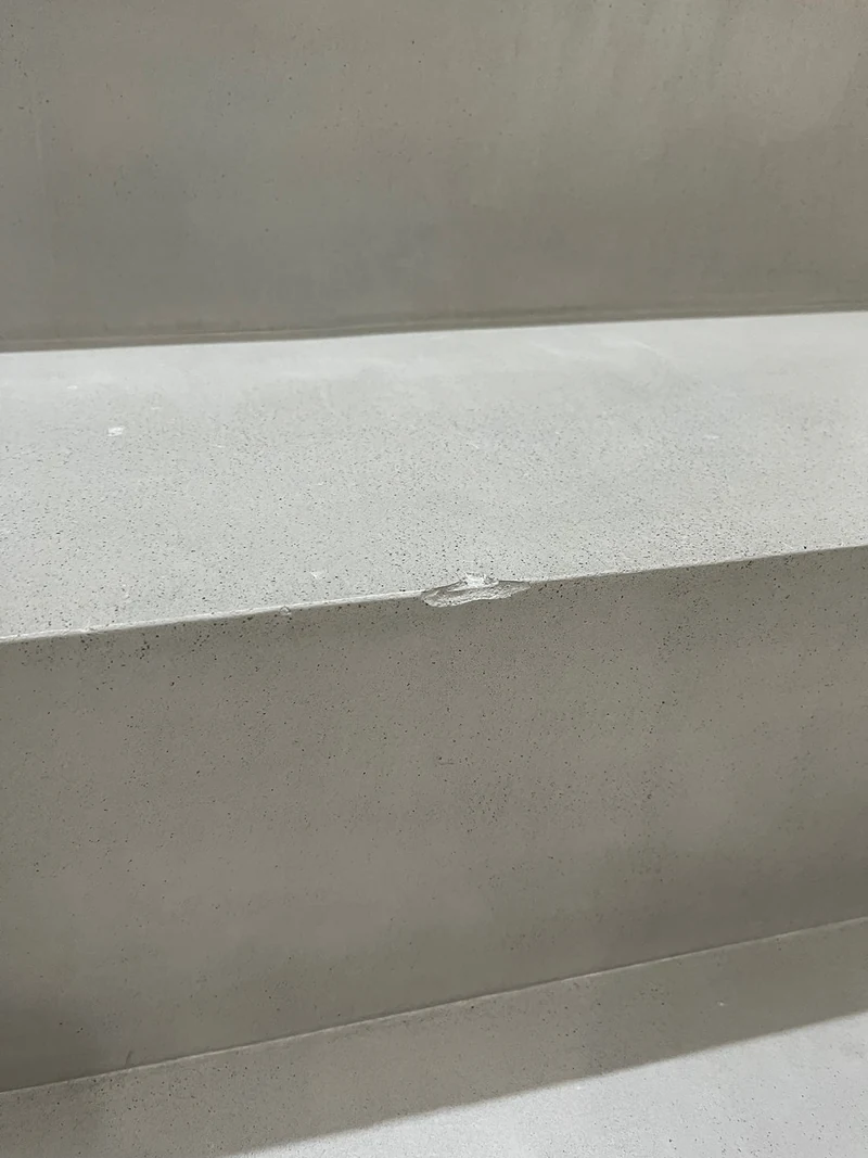 Zweite beschädigte Stelle an einer Stufenkante der beschichteten Treppe in Marl, kleine Abplatzung im Beton Ciré